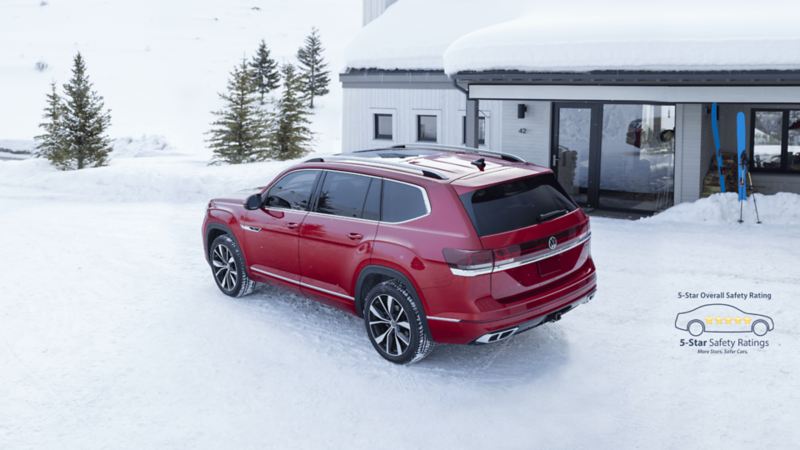 The red 2024 Volkswagen Atlas driving on the road covered with snow