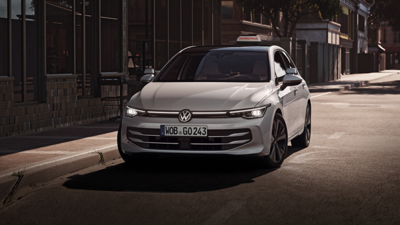 VW ID.3 fährt auf einer Straße. Auf dem Dach steht ein Fahrschule-Schild