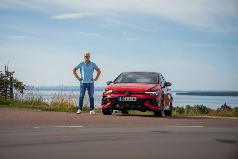 Hans står bredvid en röd Golf GTI Edition 50 i sommarmiljö.