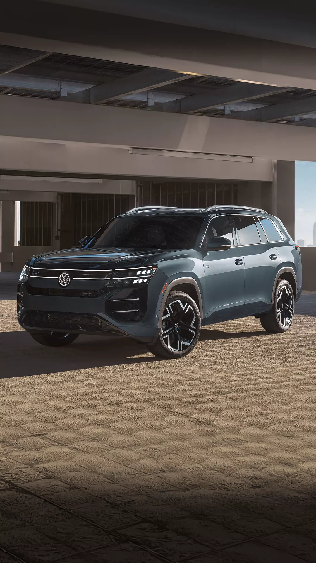 A Volkswagen Atlas parked inside a concrete parking structure. 