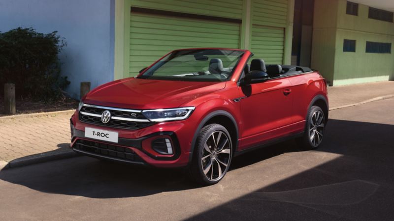 Rotes VW T-Roc Cabriolet mit geöffnetem Dach parkt am Strassenrand.