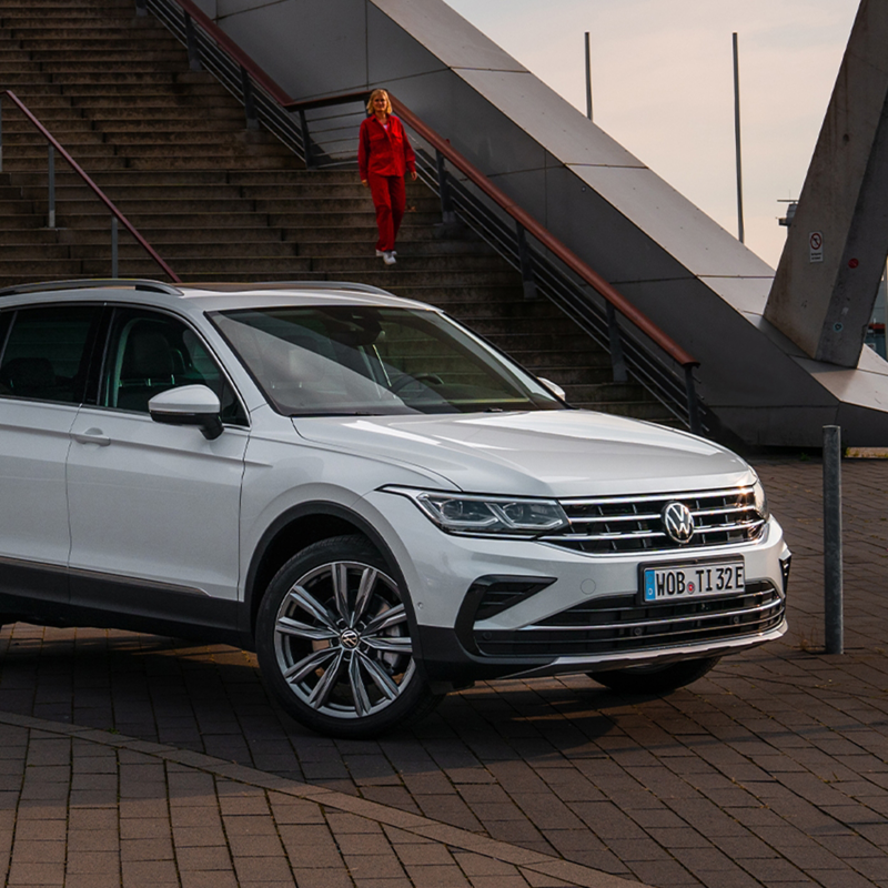 A white VW Tiguan parked by a set of stairs outside