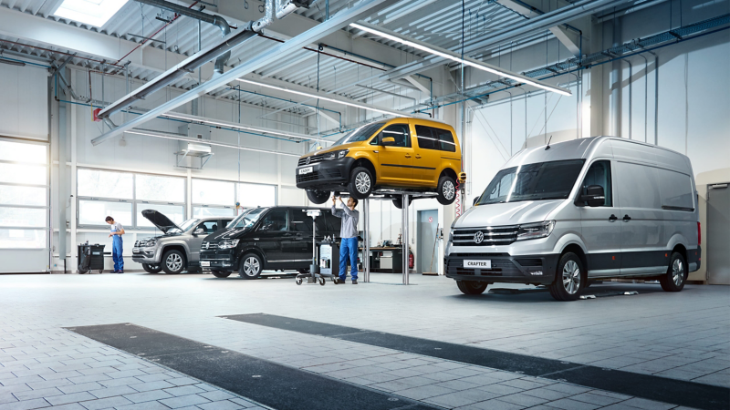 Dostawcze Volkswageny stoją na stanowiskach w serwisie.