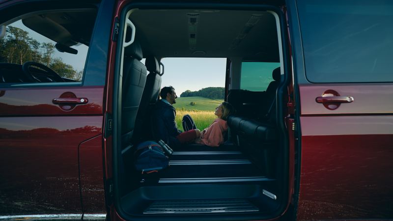 鋼琴紅色的Multivan開著車門，車主和老婆一邊聊天一邊望著窗外的美景