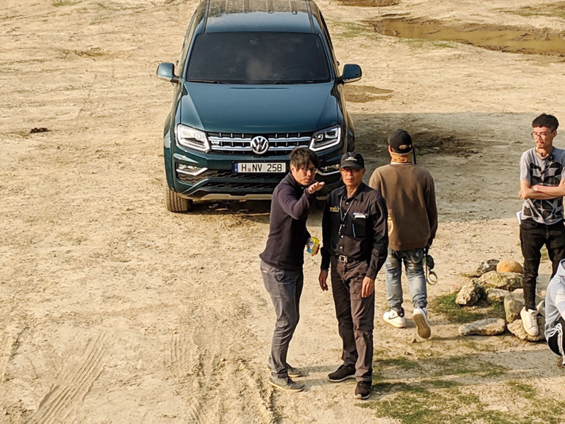 Amarok V6廣告拍攝現場紀錄，導演與攝影師站在星空藍色的Amarok前討論拍攝內容