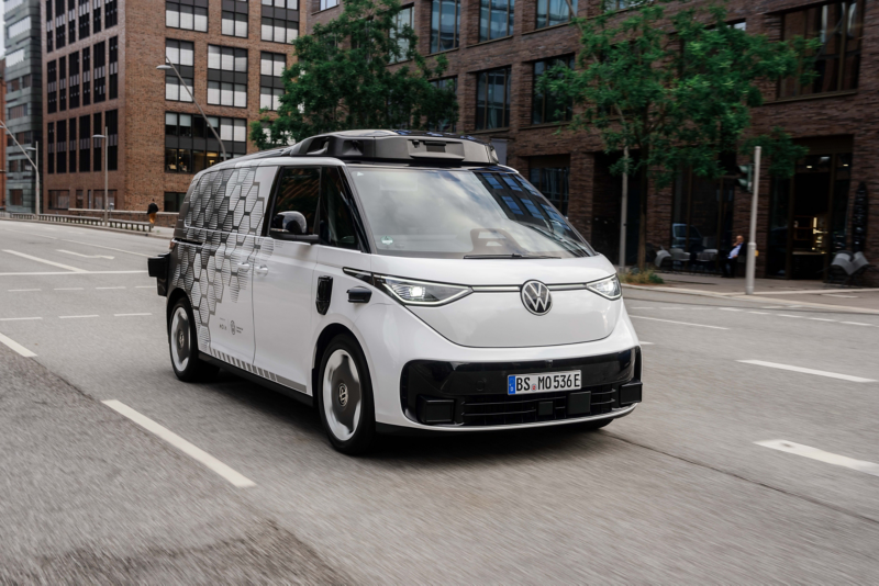 Ein weißer Volkswagen MOIA fährt auf einer Straße.