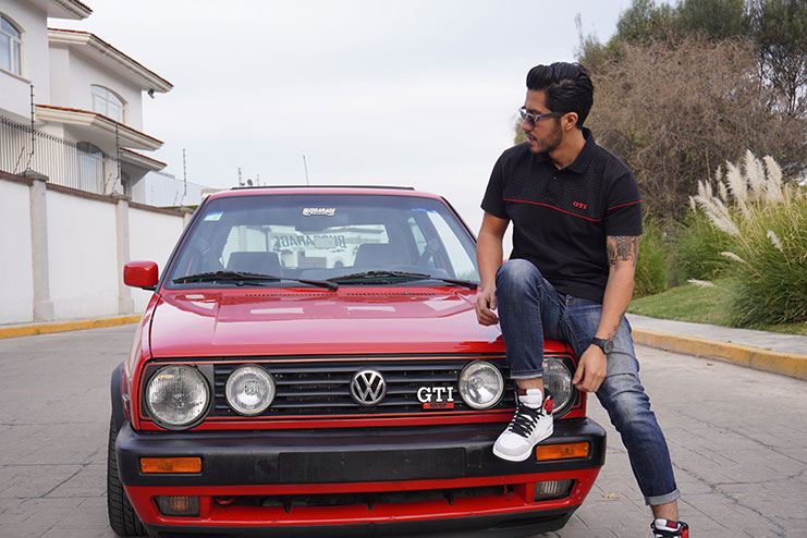 Alex sobre un Golf GTI antiguo rojo
