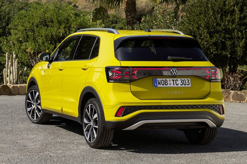 Le VW T-Cross jaune de dos, dans un paysage méditerranéen.