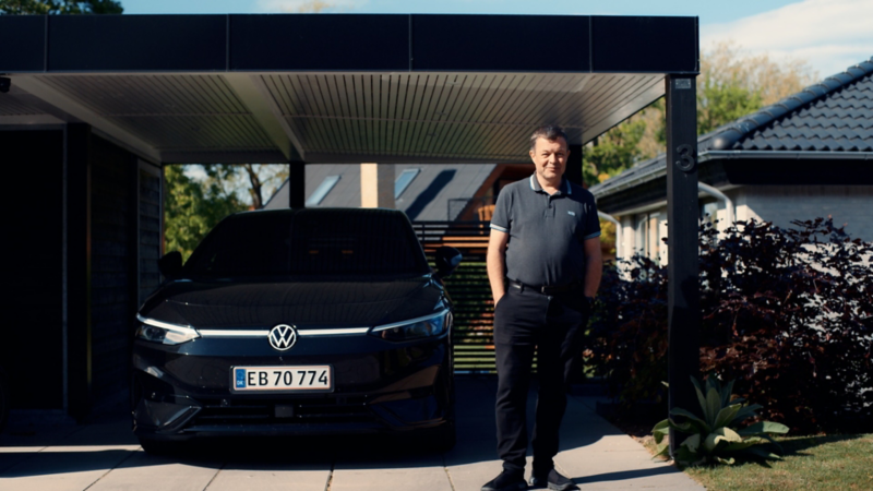 En mand står foran sin sorte ID.7 parkeret i carport