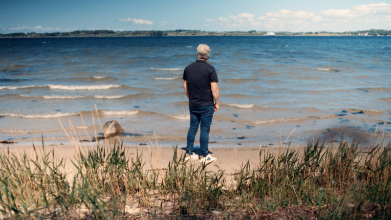 Peder står på en strand