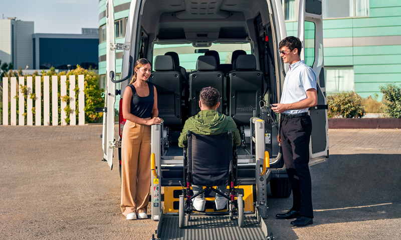 Una persona en silla de ruedas encima de la plataforma elevadora del VW Crafter People PMR