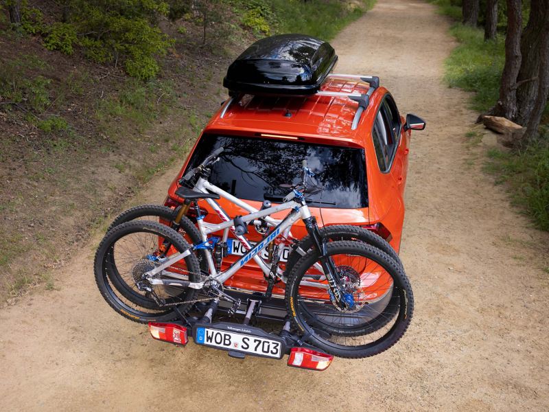 Ein VW Tiguan Allspace mit einer Dachbox und einem Fahrradträger