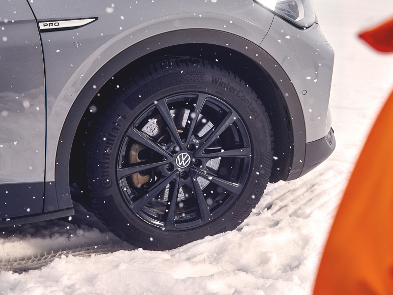 Primo piano di una ruota invernale del VW ID.4 Pro su una strada innevata.