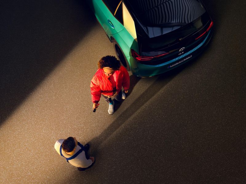 A customer hands over her ID.3 to the VW Service employee