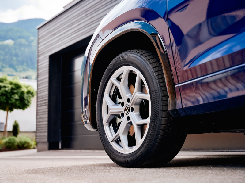 Detailaufnahme VW Rad an einem VW Tayron, das vor modernem Haus steht