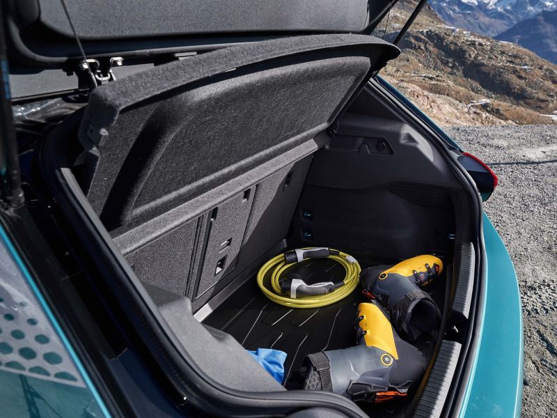 Ein geöffneter Kofferraum eines ID.3 1st mit Skischuhen und Ladekabel – VW Zubehör 