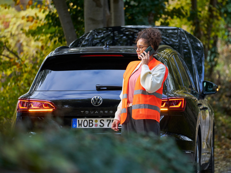 Frau vor VW Auto ruft Volkswagen Notdienst an