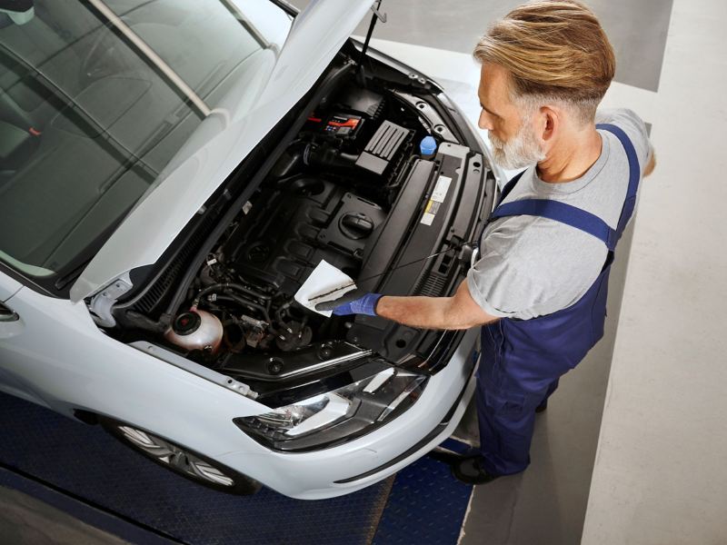 Un empleado del servicio técnico de VW comprueba el nivel de aceite de un Sharan en el taller 