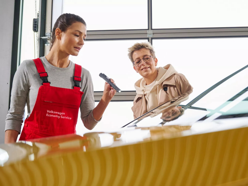 Servicemonteur en Volkswagen klant bekijken ruit van auto
