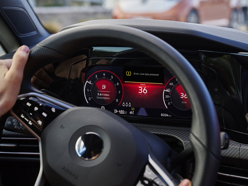 Close-up van VW-cockpit met oplichtend waarschuwingslampje