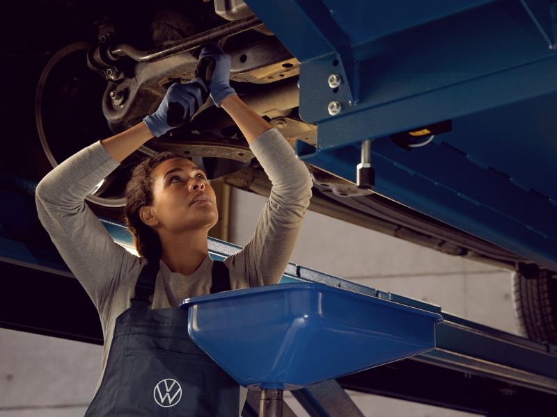 Une technicienne Volkswagen effectue une réparation complémentaire sur une Volkswagen en atelier