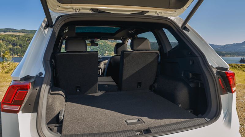 Le coffre d’un VWUS Tiguan 2022 de Volkswagen blanc pur avec les sièges rabattus pour offrir un espace de chargement modulable.