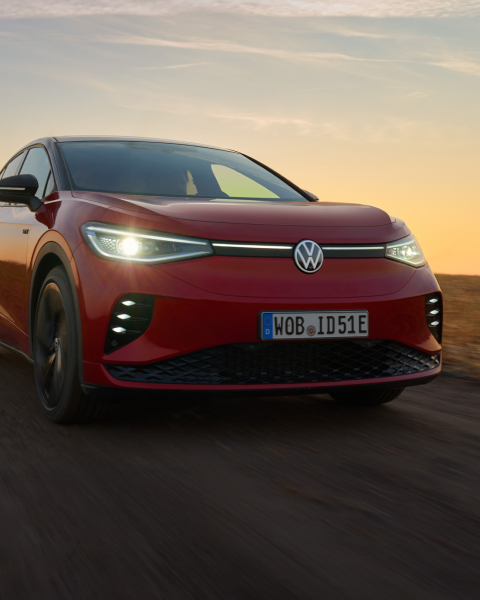 Un Volkswagen de color rojo circulando por una carretera