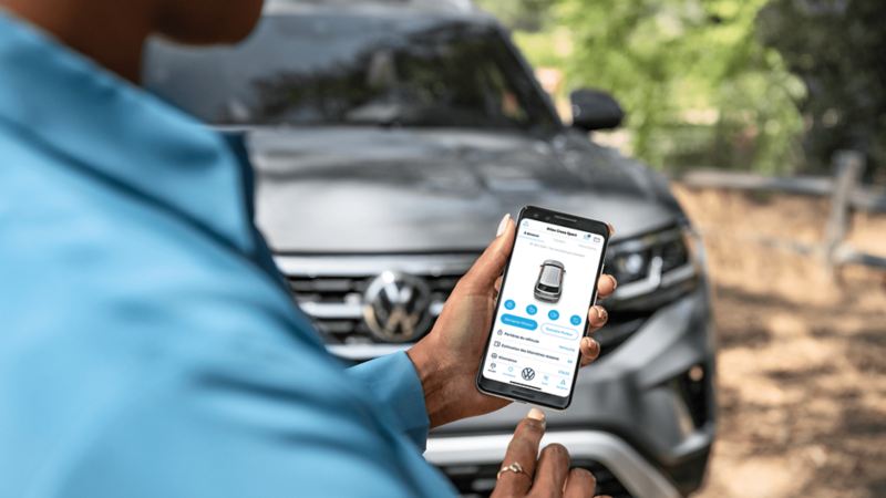 L’application Car-NetMD utilisée sur un téléphone avec un véhicule Volkswagen en arrière-plan