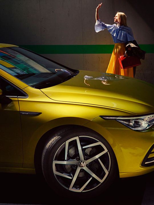 Vista lateral de un Volkswagen Golf amarillo aparcado