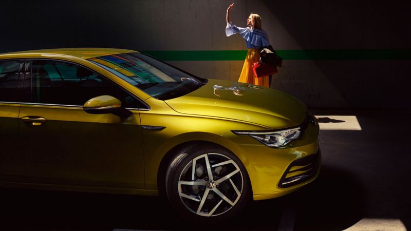 Vista lateral de un Volkswagen Golf amarillo aparcado