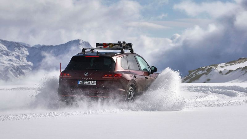 Un Volkswagen Touareg et sa technologie 4Motion roule sur une route fortement enneigée.