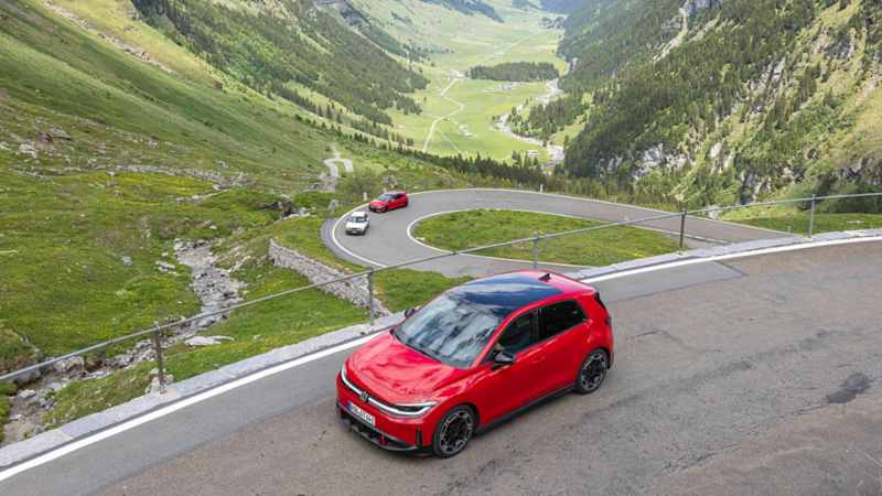 Tre generazioni della Volkswagen GTI su una strada di montagna nelle Alpi.