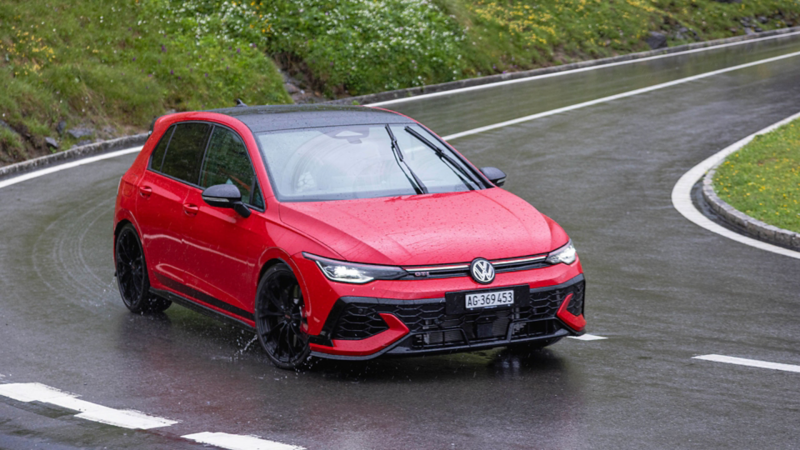 Volkswagen Golf GTI di ottava generazione su una strada di montagna sotto la pioggia.