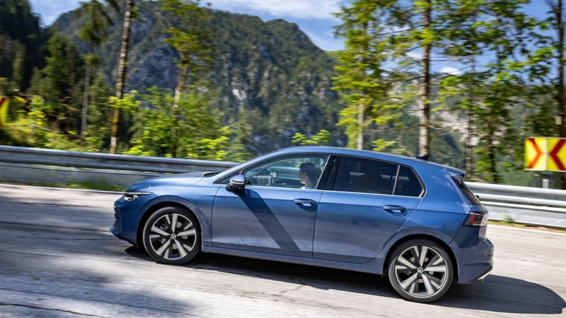 Une VW Golf neuve roule sur une route de campagne