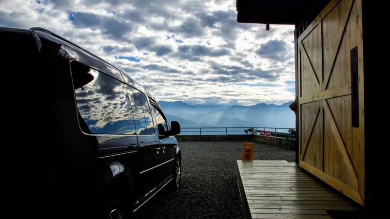 漠地棕色Caddy Maxi車身反射遠方群山及雲海景