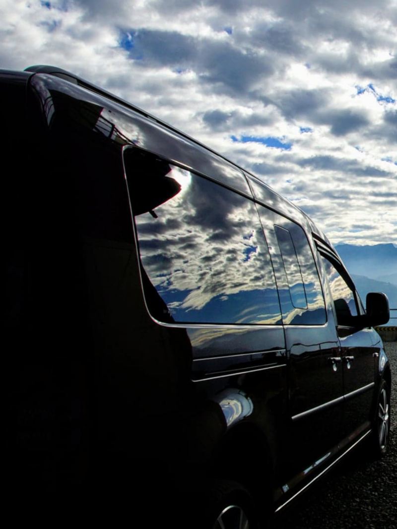 漠地棕色Caddy Maxi車身反射遠方群山及雲海景