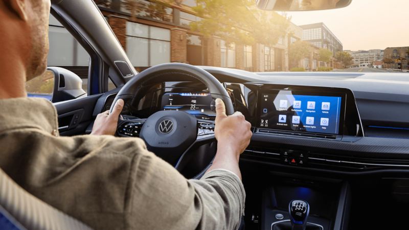 A man is driving the 2024 Golf R with a  view of the Head-Up Display
