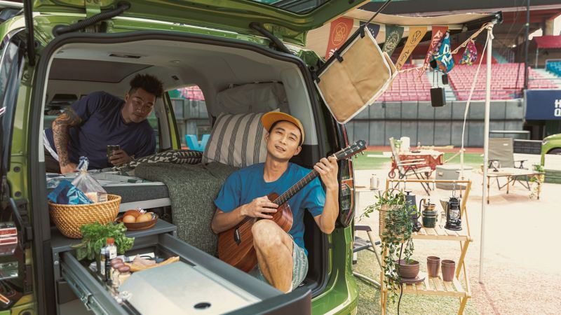 浩子在Caddy Calfornia車上彈吉他，郭泓志則側躺在車上
