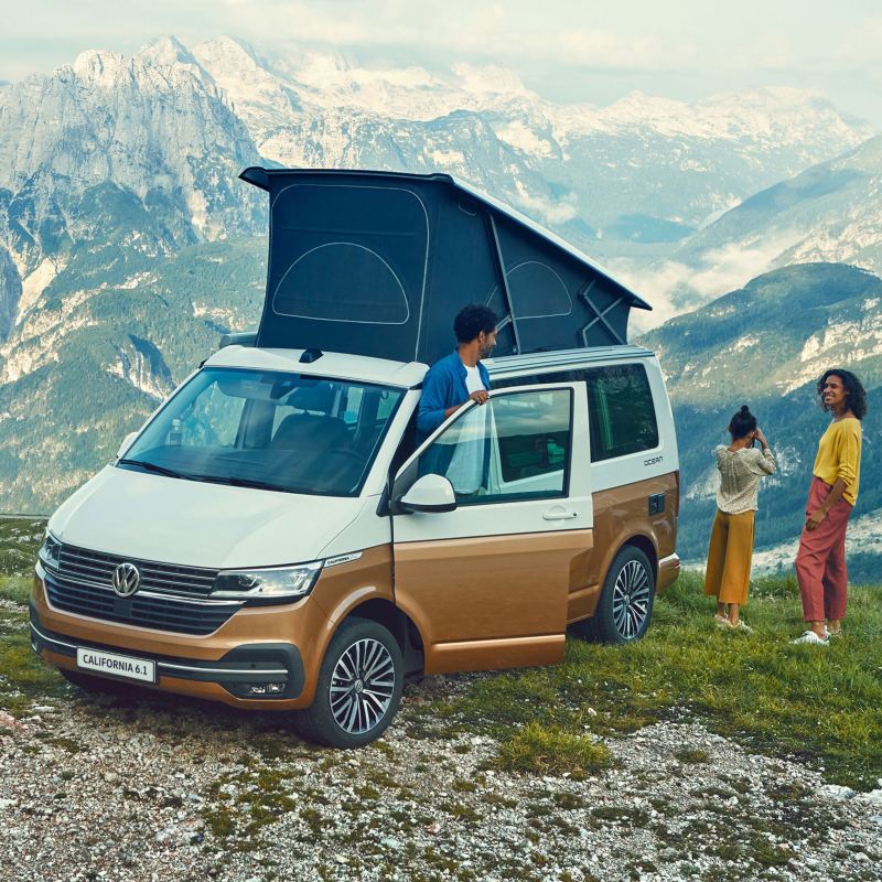 Rodzina w Volkswagen California 6.1 w punkcie widokowym w górach.