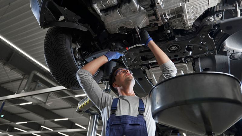 Un employé de VW services vérifie le niveau d’huile d’une voiture de VW