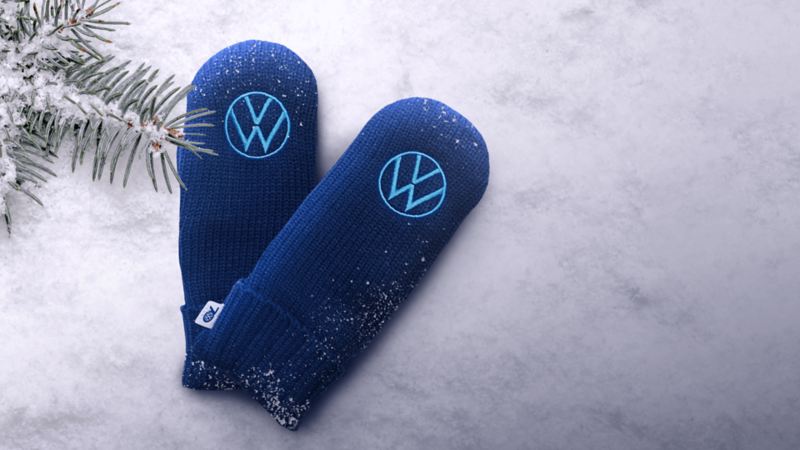 A pair of blue VW mittens laying in the snow.