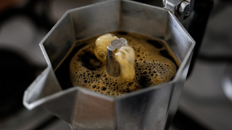 Close-Up auf einen Espressokocher, in dem gerade der frische Kaffee hochbrüht.