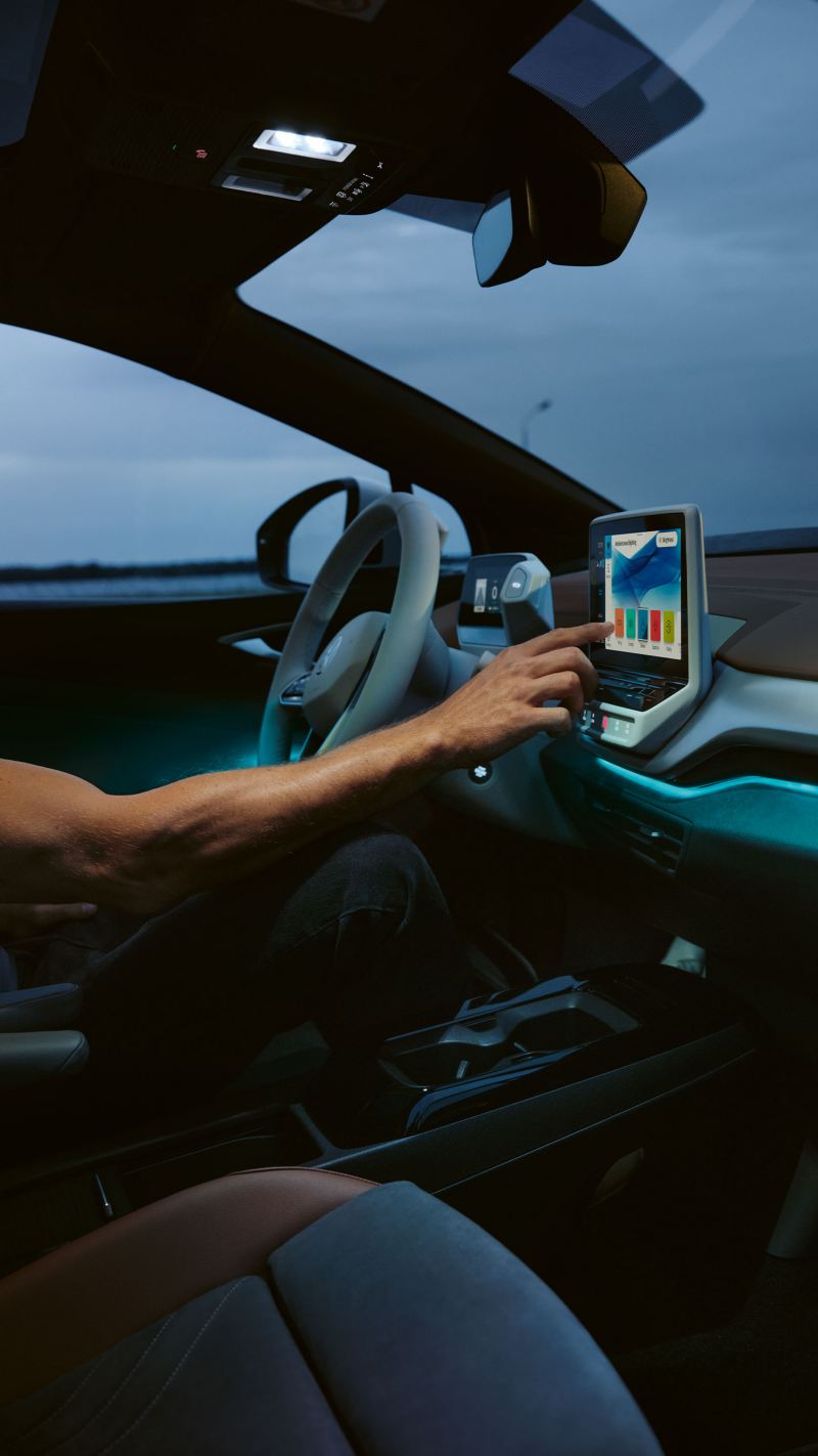 Une main utilise l’écran d’un modèle VW ID.