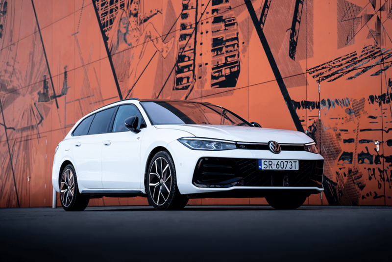 Biały Volkswagen na tle pomarańczowej ściany.