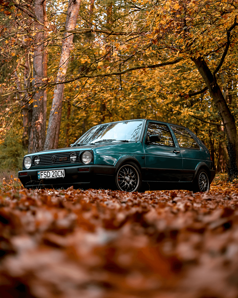 Zielony Volkswagen w jesiennym krajobrazie. 