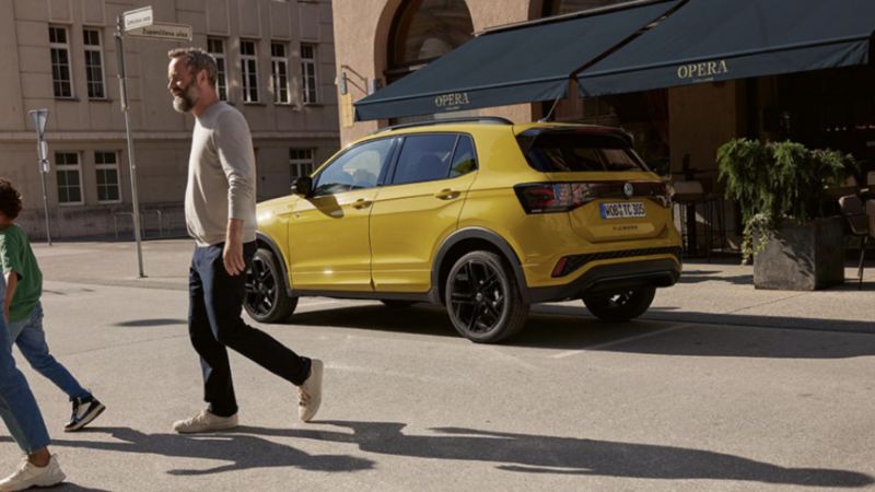 Volkswagen T-Cross amarillo aparcado al lado de una cafetería