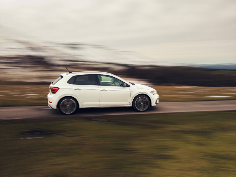 A white Polo GTI in motion on a mountain road