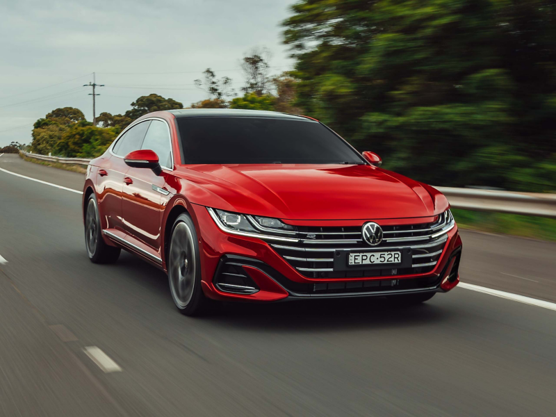 Red Sedan driving on the road