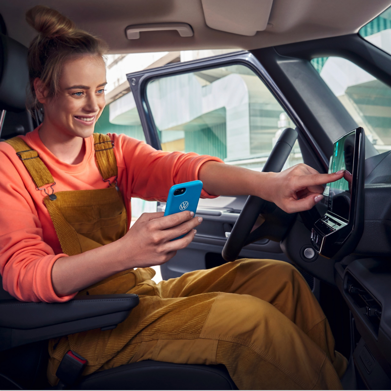 Photo showing the interior cockpit section of the ID. Buzz Cargo with a woman using the infotainment module. 