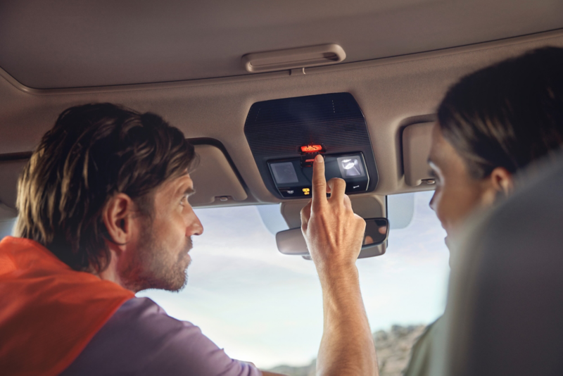 El VW Nuevo California aparcado en la orilla junto a dos personas.